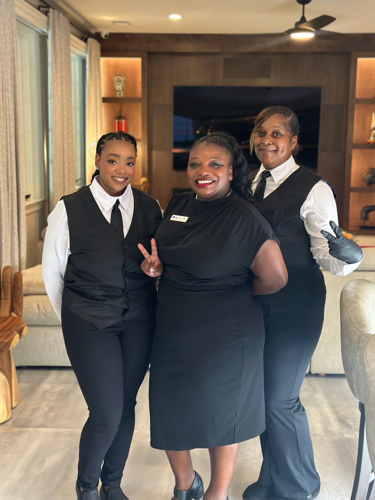 Three uniformed waitstaff members ready to receive guests