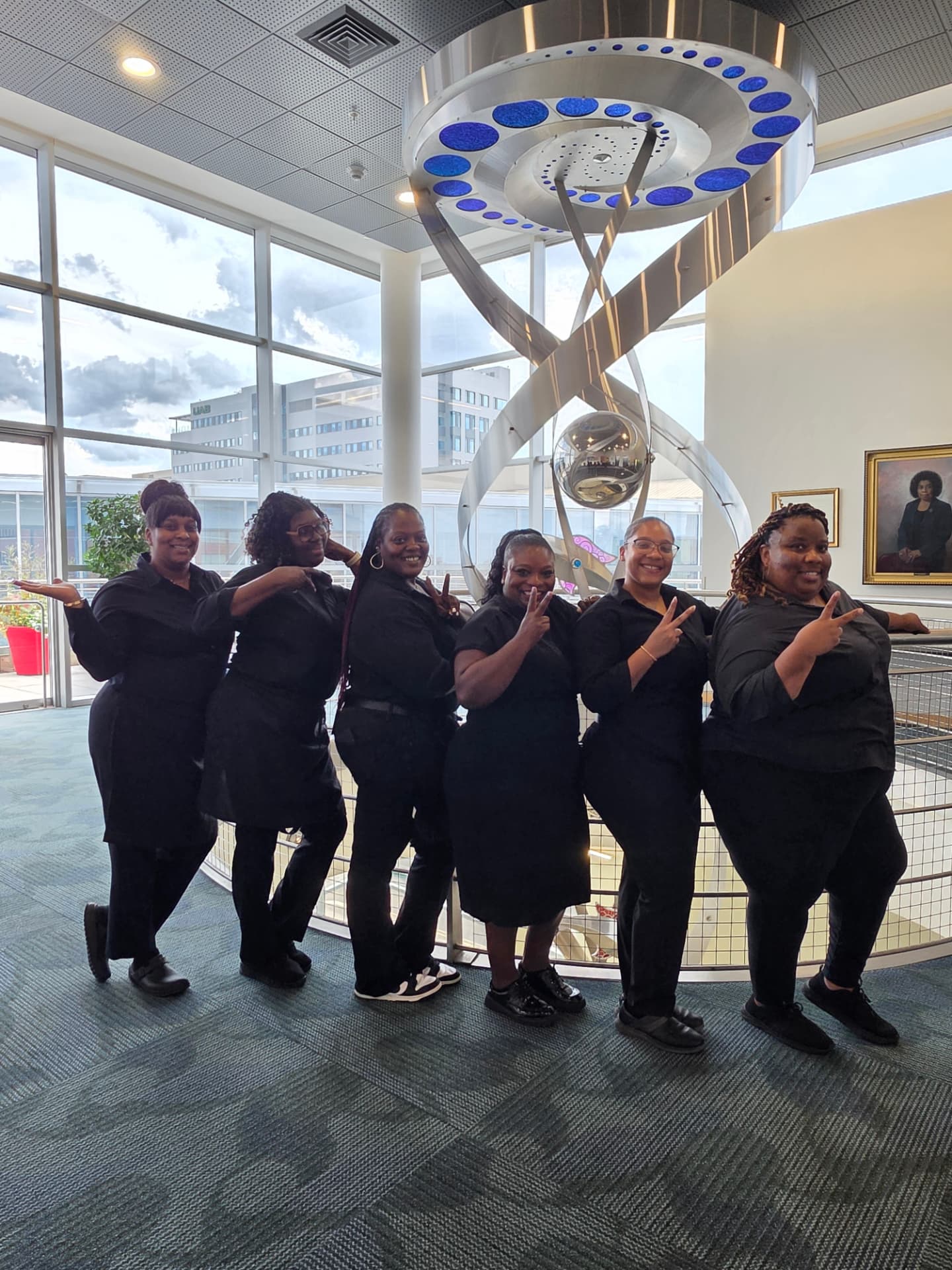 The 2 Girlz and A Tray team posing together in a bright modern venue